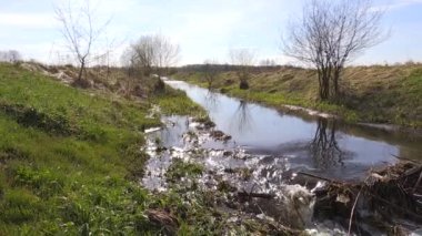 İlkbaharda yeşil alan ile çöp barajı arasındaki nehir suyu akışı