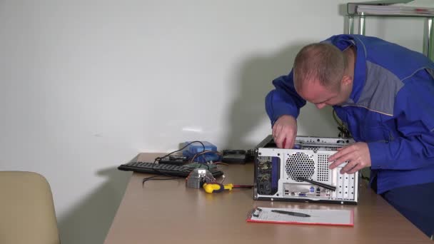Мужчина чинит компьютер и отдает отремонтированный ноутбук женщине-клиенту — стоковое видео