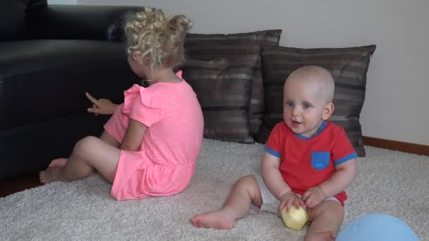 Erkek ve kız kardeş evde eğlenirler. Küçük çocuklar gülüyor — Stok video
