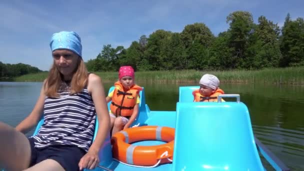 Moeder wiel catamaran pedalen. Twee kleine kinderen op achterzetels. Gimbal Motion — Stockvideo