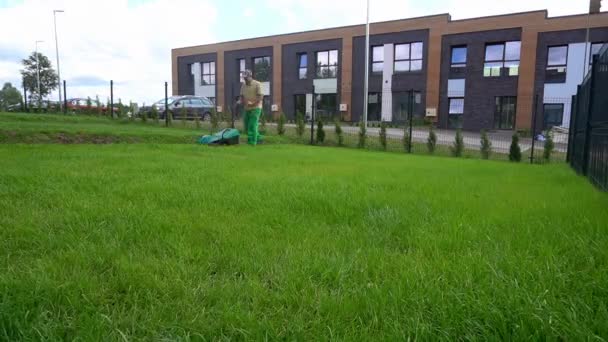 男は曇りの日に芝刈りをしている。広角タイムラプス — ストック動画
