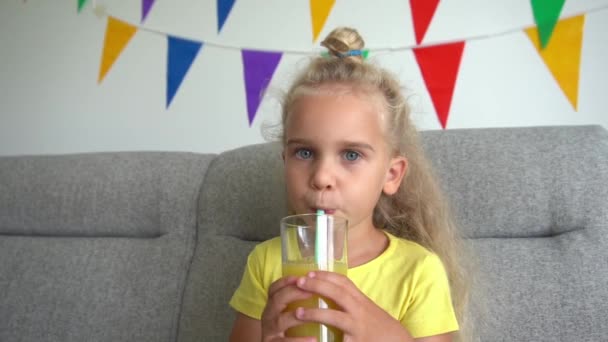 Blond flicka barn dricker vatten från glas med pinne. Gimbal slow motion närbild — Stockvideo