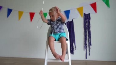 Wicked iki yaşındaki çocuk doğum günü partisinden sonra balon ile oynamak. yavaş çekim