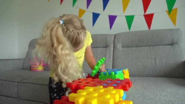 4 år gammal flicka spela på soffan. Creative barn församling spel delar. Gimbal rörelse — Stockvideo