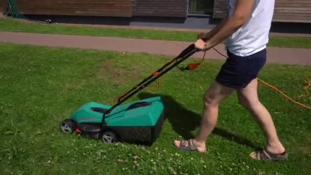 Kvinnlig push gräsklippare skära gräs i privat hus gård. Gimbal följ sidan — Stockvideo