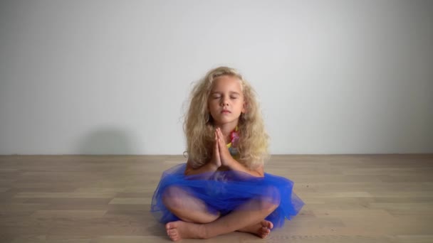 Mooi meisje Kid zittend op de vloer thuis ontspannen. Yoga concept. Gimbal-beweging — Stockvideo