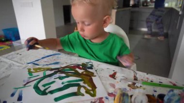 fırça ile closeup küçük çocuk boya. küçük yaratıcı sanatçı çalışmalarına odaklandı