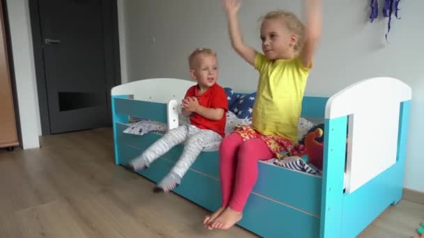Húga és testvére ül az ágyban taps kezét és szerető apa ember. Gimbal mozgás — Stock videók