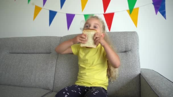 Το πεινασμένο όμορφο κορίτσι τρώει φέτα λευκού ψωμιού. Κίνηση αναρτίδα — Αρχείο Βίντεο