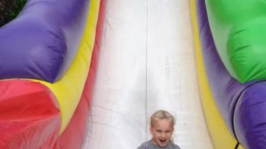 mutlu aktif kız aşağı oyun şişme trambolin üzerinde slayt. Gimbal hareketi