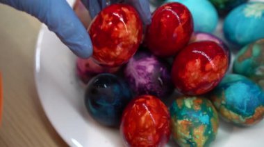 Hand put painted Easter egg in dish full of beautiful eggs. Gimbal shot