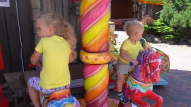 Mutlu çocuklar oğlu ve kızı atlıkarınca üzerinde spin. Etrafında Gimbal hareketi