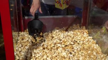 Kadın elleri kağıt torbaya tatlı patlamış mısır koyar. Açık hava fuarında patlamış mısır satışı