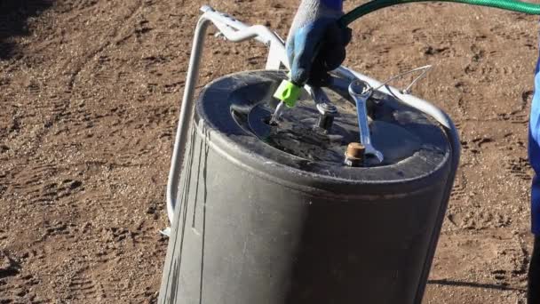 Hand houder slang vulling bodem compactere gereedschap met water. Statisch schot. — Stockvideo
