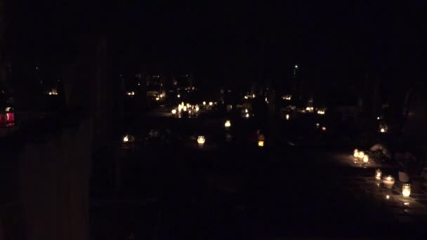 Могила с горящими свечами на кладбище ночью. 4K — стоковое видео