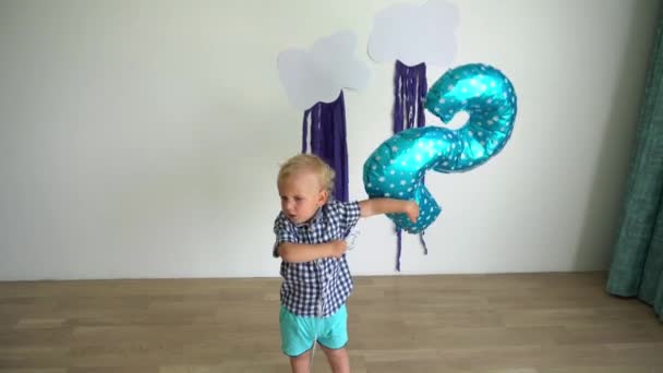 Un niño de dos años juega con un globo. Movimiento de cardán — Vídeos de Stock