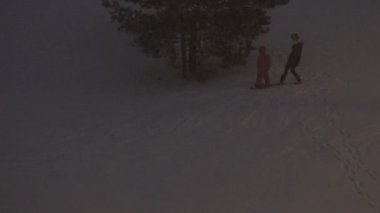 Küçük tepeden snowboard 'la kayıyor ve kar yağıyor. 4K