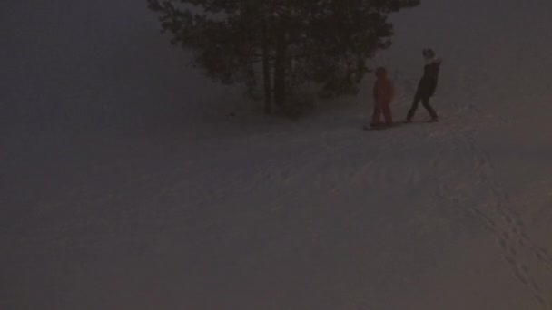 小さな丘からのスノーボードと秋の雪で子供のスケート。4K — ストック動画