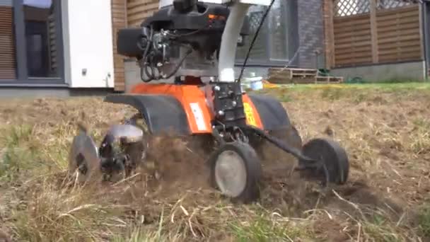 Mann pflügt Stadthaus Hof mit Grubber. Vorbereitung auf die Rasensaat. Gimbalenbewegung — Stockvideo