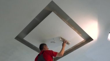 Spatül ve dolgu malzemesi ile tavanı tamir eden tamirci