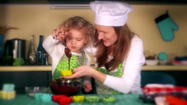 Happy mother and daughter preparing cupcakes in kitchen. Dramatic color grading — Stock Video