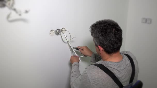 カッター工具でワイヤ絶縁を除去する男 — ストック動画