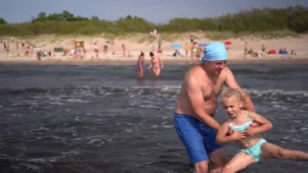Játékos apa viszont splash aranyos lánya tengeri hullámok — Stock videók