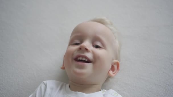 Lindo niño ríete mientras alguien le hace cosquillas. Movimiento del cardán — Vídeos de Stock