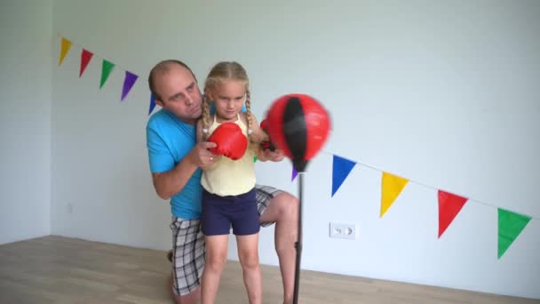 Happy father teach adorable daughter box technique on boxing pear — Stock Video