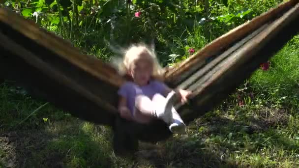 Cute little girl swinging na hamaku — Wideo stockowe