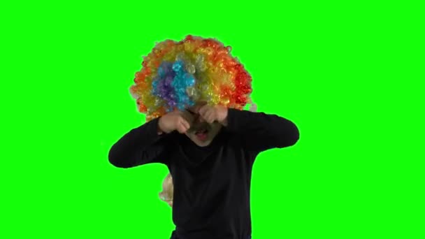 Sad girl with clown wig pretending as crying. Green screen — Stock Video