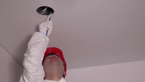 Man worker make hole in the ceiling for lighting LED lamps. 4K — Stock Video