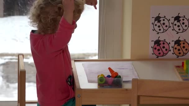 Menina alegre desenha com giz enquanto sentado à mesa. Infância e jogo. 4K — Vídeo de Stock