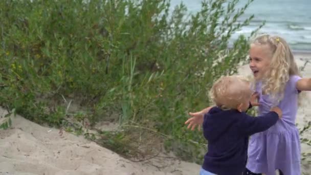 Adorabili bambini che combattono sulla sabbia delle dune. Fratello e sorella divertirsi in spiaggia — Video Stock