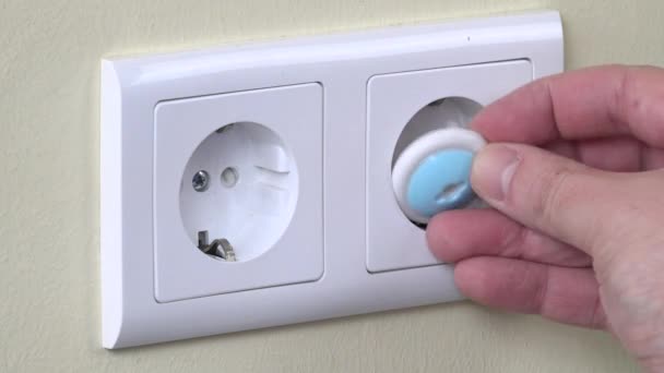 Man hand covered electricity outlet on wall with safety plug. 4K — Stock Video