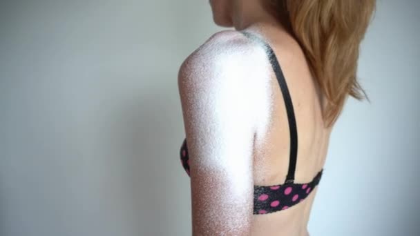 Жінка стоїть в бюстгальтері і руці наносить пантенол спрей на плече після сонячного опіку — стокове відео