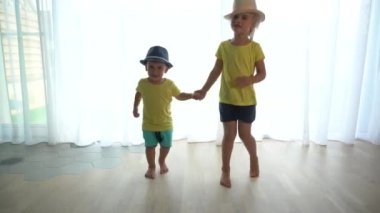 Komik çocuklar. Küçük kız ve erkek kardeşler el ele tutuşup koşun.