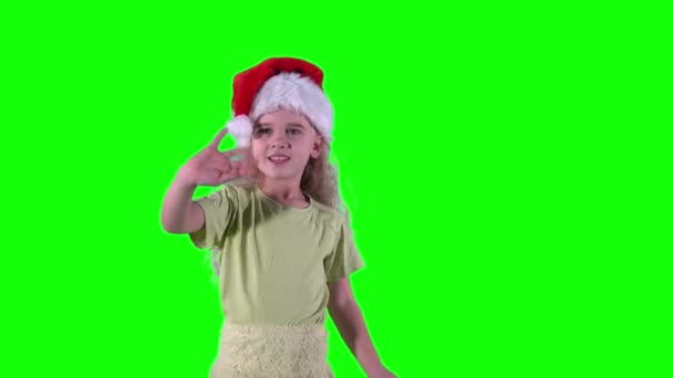 Aranyos szőke lány, Mikulás kalapot lengető kezekkel. Chroma kulcs zöld háttér. — Stock videók