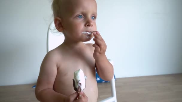 汚れた少年は棒にチョコレートでアイスクリームを食べています。ジンバル・モーション・ショット. — ストック動画
