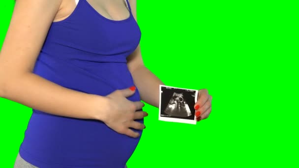 Femme enceinte ventre et main tenir petite photo de grossesse. Écran à clé chroma. 4K — Video