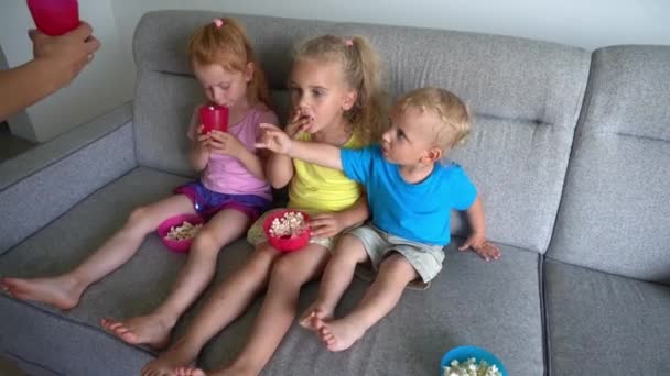 Γυναικείο χέρι δώσει κύπελλο με χυμό για τα παιδιά βλέποντας τηλεόραση — Αρχείο Βίντεο