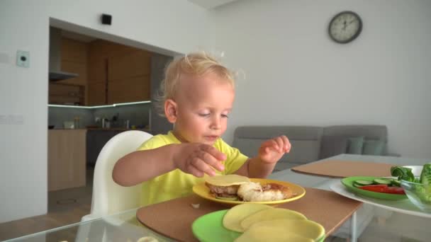 Vicces gyerekek játszanak burger összetevők ül asztalnál a nappaliban — Stock videók