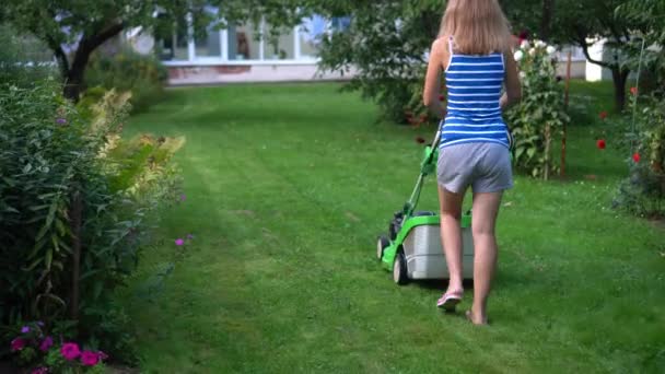 Woman cuts the grass lawn with petrol engine lawn mower — Stock Video