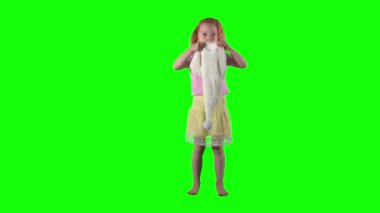 Başında Noel Baba şapkasıyla yaramaz kızıl saçlı kız çocuk dansı yapıyor..