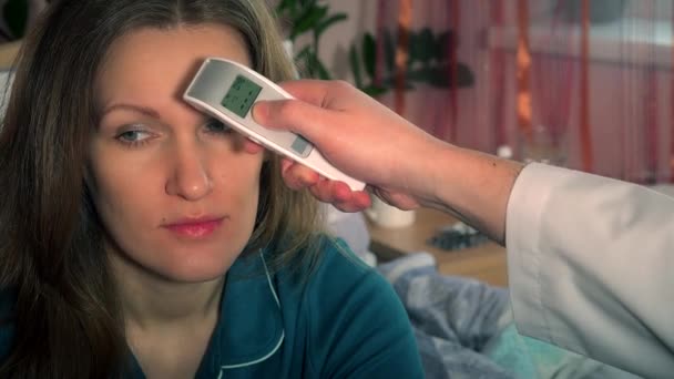 Arzt misst Frau Stirn mit Infrarot-Multifunktionsthermometer. — Stockvideo