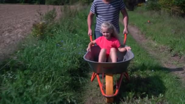 Nonno spingendo sua nipote in una carriola — Video Stock