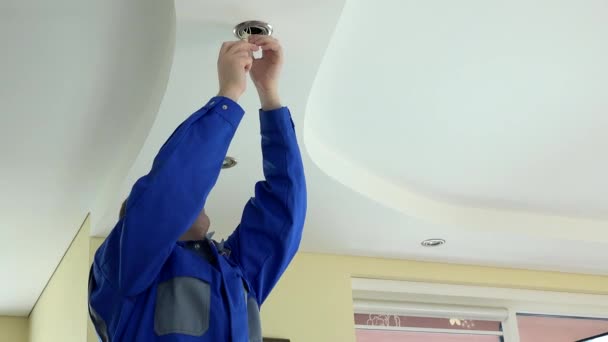 Electricista hombre cambiar bombilla led en el techo en la habitación. 4K — Vídeo de stock