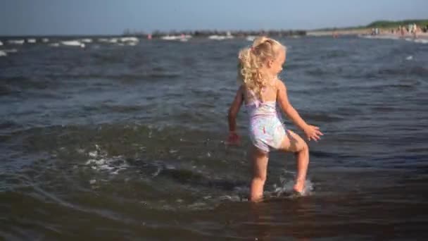 Chica activa patadas salpicaduras olas de mar con piernas — Vídeos de Stock