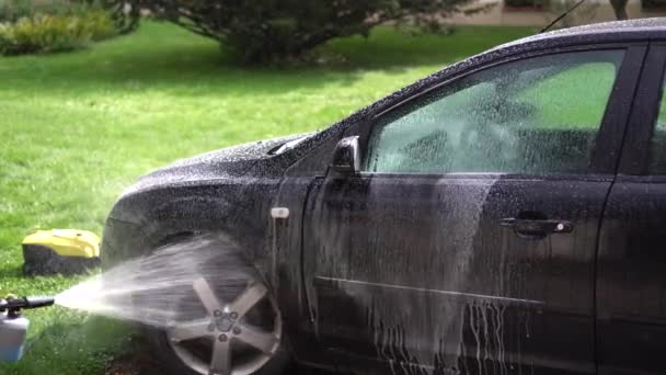 Homem pulverizar sabão de espuma de lavagem em seu carro automóvel no jardim quintal — Vídeo de Stock