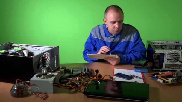 Počítačový mechanik testuje části počítače proti datům v tabletu. 4K — Stock video